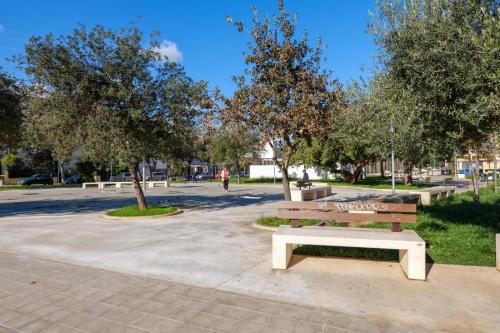 a park bench sitting in a park with trees at Villa Reale Flats in Lecce