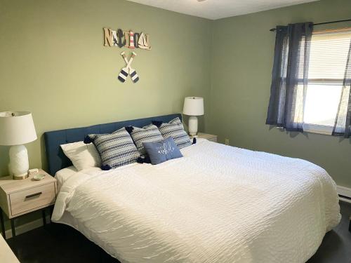 - une chambre dotée d'un grand lit avec des draps et des oreillers blancs dans l'établissement Oasis on Empire in Thornville, à Thornville