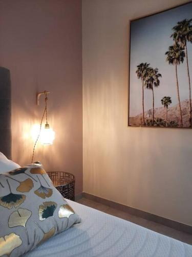 - une chambre avec une photo de palmiers sur le mur dans l'établissement La régate avec jaccuzi à 50 m du centre historique, à Sarlat-la-Canéda