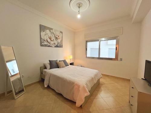 Convenient 2 Bedroom with Seaview في طنجة: غرفة نوم بسرير كبير وتلفزيون