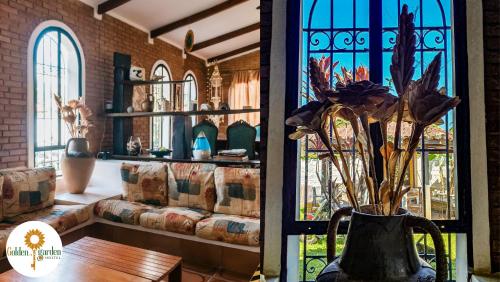 a living room with a couch and a vase with flowers at Golden Garden Hostel in Ubatuba