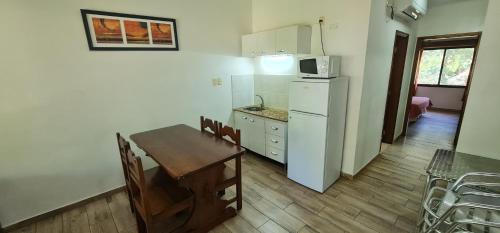 a kitchen and dining room with a table and a refrigerator at Termas Posada del Siglo XIX in Termas del Daymán