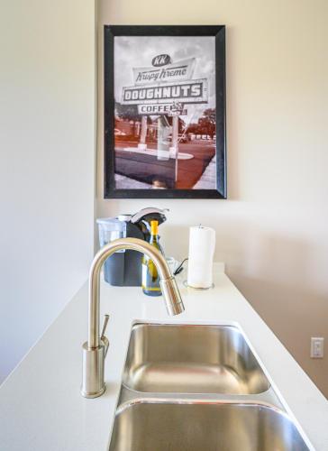 a kitchen counter with a sink and a picture on the wall at Revisn in Raleigh