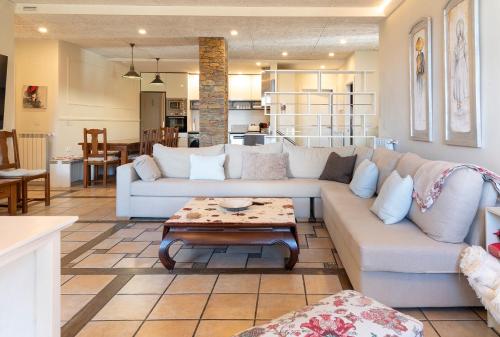 ein Wohnzimmer mit einem Sofa und einem Tisch in der Unterkunft PRADOS DE VELARTA in Aramón Cerler