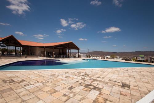 uma grande piscina com um pavilhão e céu azul em Casa de campo c lazer completo e WiFi Bezerro PE em Bezerros