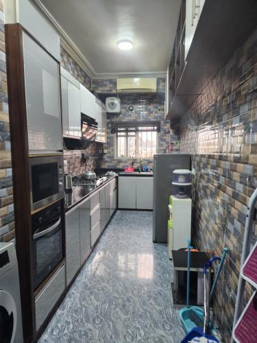 una grande cucina con elettrodomestici bianchi e pareti in mattoni di Tastefully furnished apartment a Port Harcourt