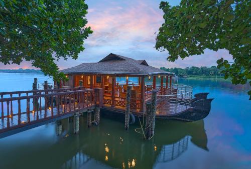 una cabaña en un muelle sobre un cuerpo de agua en The Leela Ashtamudi, A Raviz Hotel, en Kollam