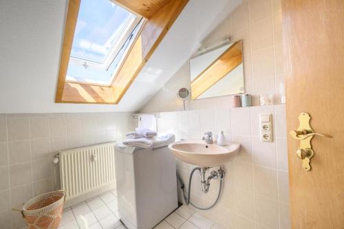ein Bad mit einem Waschbecken, einem WC und einem Fenster in der Unterkunft Ferienwohnung Lampl 7 in Bad Kohlgrub