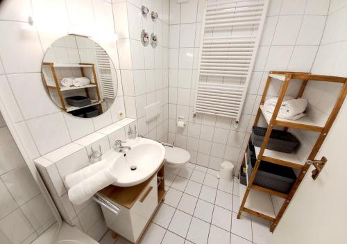 a white bathroom with a sink and a mirror at Holiday apartment Sybille in Bad Kohlgrub in Bad Kohlgrub