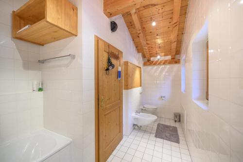 a bathroom with a toilet and a sink and a door at Ferienhaus Alpenliebe in Grainau in Grainau