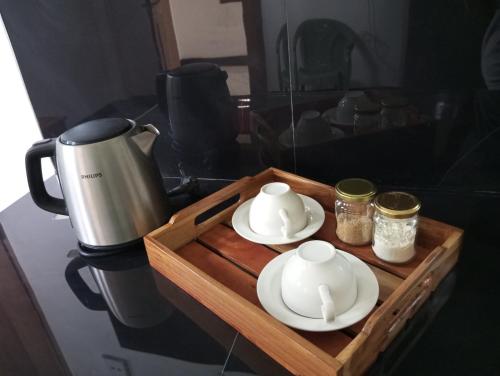 a coffee maker and two cups on a wooden tray at Windy Villa in Polonnaruwa