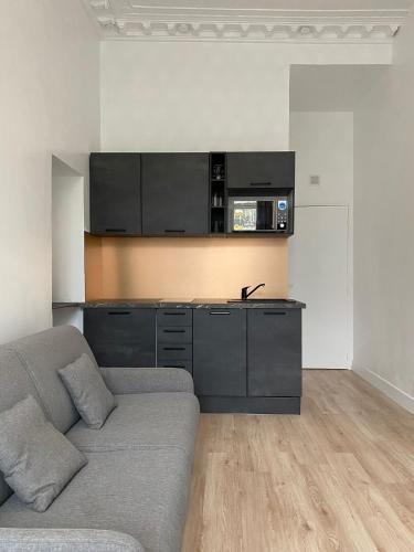 un salon avec un canapé et une cuisine dans l'établissement Studio Montorgueil, à Paris