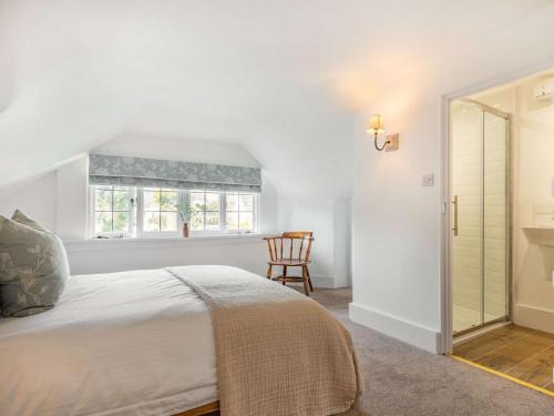 a bedroom with a bed and a window and a chair at 3 bed property in Bantham 87005 in Thurlestone