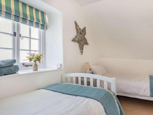a bedroom with two beds and a starfish on the wall at 3 bed property in Bantham 87005 in Thurlestone
