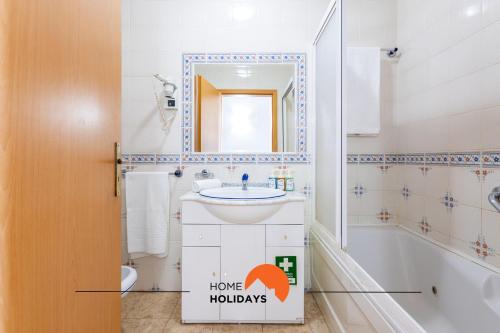 ein Badezimmer mit einem Waschbecken, einem WC und einem Spiegel in der Unterkunft #198 City and Ocean View Balcony with AC Studio in Portimão