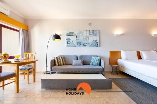 Zimmer mit einem Bett, einem Sofa und einem Tisch in der Unterkunft #198 City and Ocean View Balcony with AC Studio in Portimão