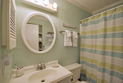 y baño con lavabo, espejo y ducha. en 304A Sea Cabin en Isle of Palms