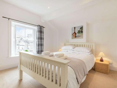um quarto com uma cama branca e uma janela em 4 Bed in Keswick 87567 em Keswick