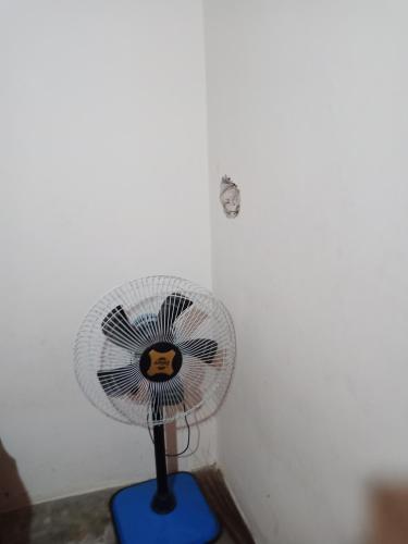 un pequeño ventilador azul en una esquina de una pared en Tourist lodge, en Kānpur