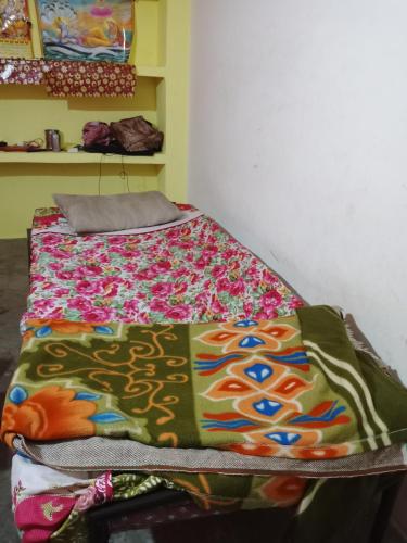 Una cama con una manta de colores encima. en Tourist lodge, en Kānpur