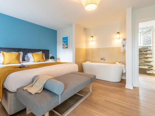 a bedroom with a large bed and a bath tub at 2 Bed in St. Mellion 87708 in St Mellion