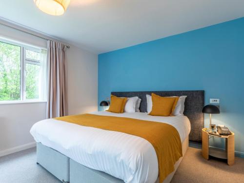 a bedroom with a large bed with orange and white pillows at 2 Bed in St. Mellion 87714 in St Mellion