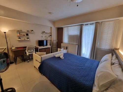 1 dormitorio con cama, escritorio y ordenador en Palm Tree Villas Condominium by Beth, en Manila