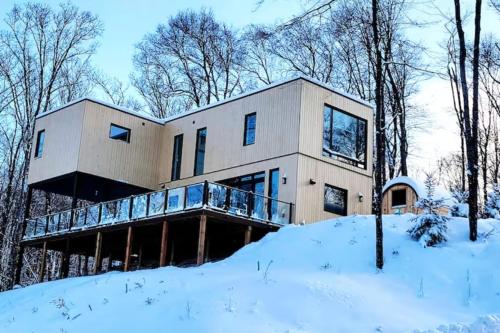 a house in the woods in the snow at The Golden View - Luxury Cottage in La Conception