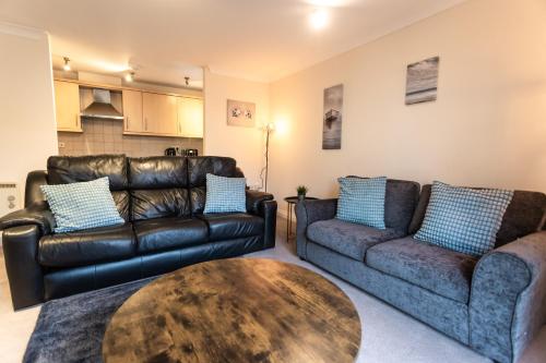 a living room with two leather couches and a table at April Disc - Long Stay - Contractors in Bristol