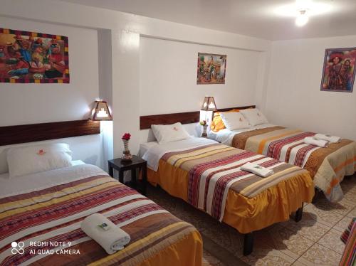 a hotel room with three beds in a room at DENNY'S MAPI in Machu Picchu