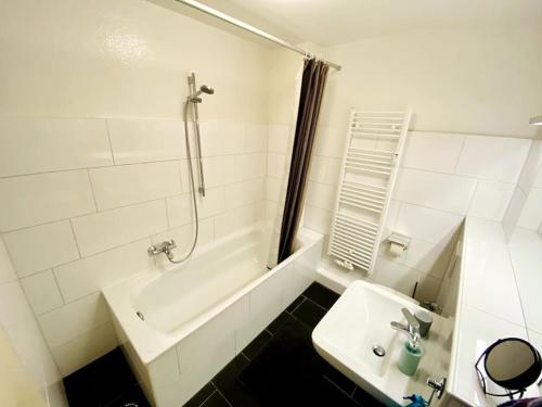 ein Badezimmer mit einer Dusche, einem Waschbecken und einer Badewanne in der Unterkunft Im Herzen von Essen - Ruhig und zentral in Essen