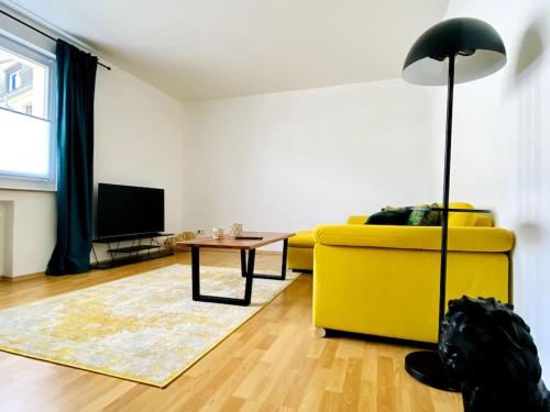 a living room with a yellow couch and a table at Im Herzen von Essen - Ruhig und zentral in Essen