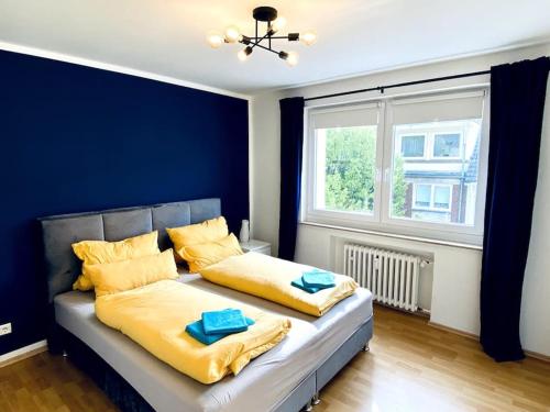 a bedroom with a bed with blue walls and a window at Im Herzen von Essen - Ruhig und zentral in Essen