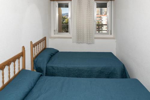 2 camas con sábanas azules en un dormitorio con 2 ventanas en Florazar 2, Vi-5-B, en Cullera