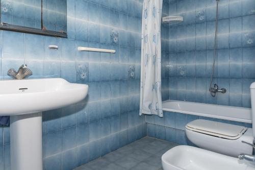 a blue tiled bathroom with a sink and a toilet at Florazar 2, Vi-5-B in Cullera