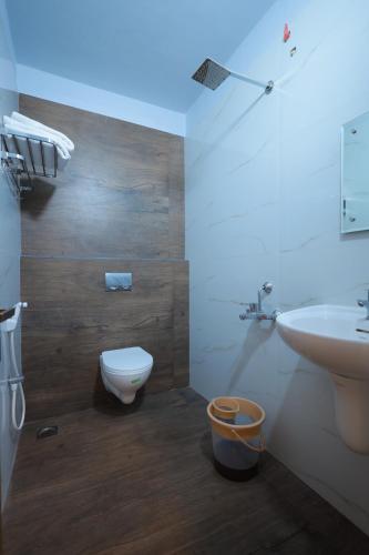 een badkamer met een wit toilet en een wastafel bij Hotel Jeyam in Kanyakumari