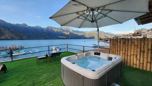 a hot tub with an umbrella on top of a balcony at NEW YORK by luxury atitlan in San Pedro La Laguna