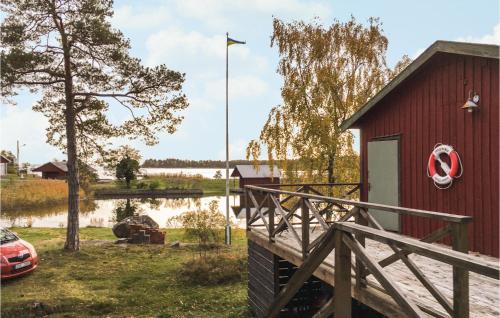 een rood gebouw met een vlag en een lichaam water bij Cozy Home In Oskarshamn With House Sea View in Oskarshamn