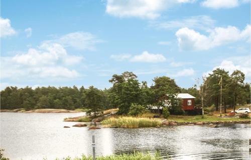 une petite maison rouge sur une île dans l'eau dans l'établissement Cozy Home In Oskarshamn With House Sea View, à Oskarshamn
