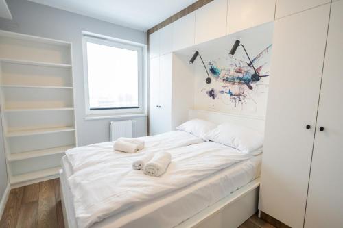 1 dormitorio blanco con 2 toallas en una cama en Blue Zeppelin en Toruń
