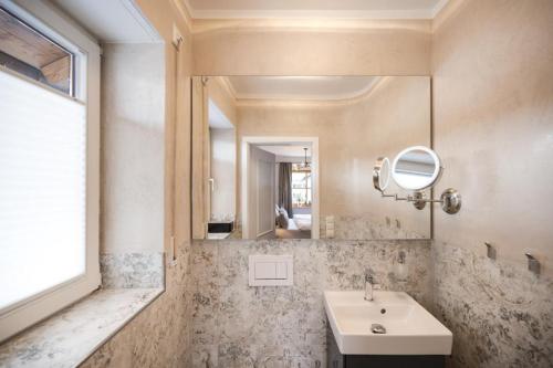 ein Bad mit einem Waschbecken und einem Spiegel in der Unterkunft Ferienhaus Die 14 mit Infrarotkabine in Garmisch-Partenkirchen