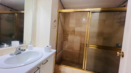 uma casa de banho com um lavatório e um chuveiro em Departamento de lujo 2 habitaciones, 2 baños, wifi, parqueadero, República de El Salvador em Quito