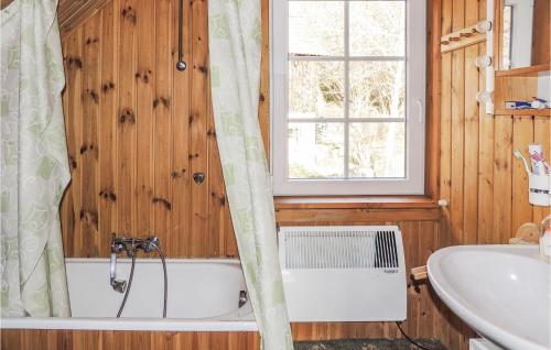 een badkamer met een bad, een wastafel en een raam bij Gorgeous Home In Weissenstein With Kitchen in Fresach