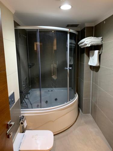 y baño con bañera, aseo y lavamanos. en MOONLİGHT HOTEL en Bostaniçi