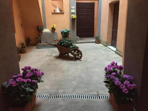 a courtyard with a bench with flowers in front of a door at Casa di Emanuela in Spello