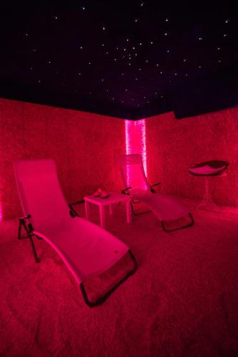 two chairs and a table in a room with red lights at Hotel Residence Montelago in Ternate