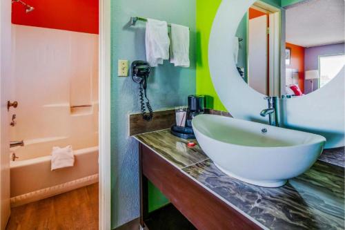 W łazience znajduje się umywalka i lustro. w obiekcie Hotel Europa Ridgecrest w mieście Ridgecrest