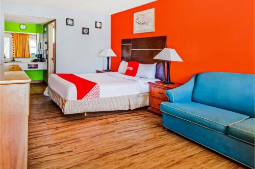 sypialnia z łóżkiem i niebieską kanapą w obiekcie Hotel Europa Ridgecrest w mieście Ridgecrest