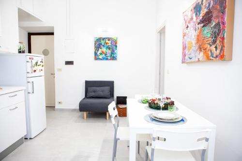 eine weiße Küche mit einem weißen Tisch und einem Stuhl in der Unterkunft Il Viandante al Pigneto - CIR 26927 - Parcheggio privato gratuito in Rom