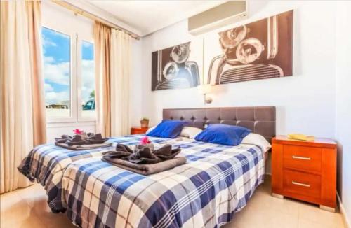 ein Schlafzimmer mit einem blauen und weißen Bett mit Handtüchern darauf in der Unterkunft Villa Luna in Yaiza